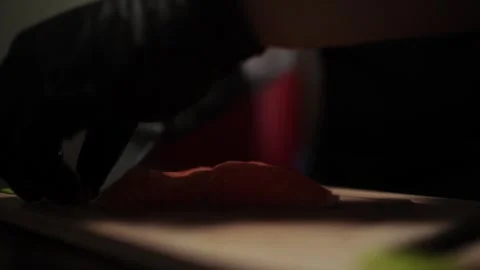 Close-Up of Hands Slicing Fresh Salmon Fillet on a Dark Background Stock-Footage 303903680