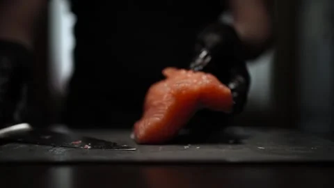 Close-Up of Hands Slicing Fresh Salmon Fillet on a Dark Background Video stock 303903733