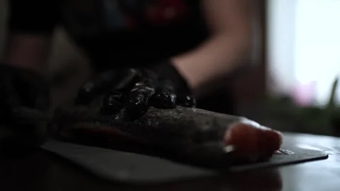 Close-Up of Hands Slicing Fresh Salmon Fillet on a Dark Background Stock-Footage 303906086