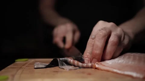 Close-Up of Hands Slicing Fresh Salmon Fillet on a Dark Background 스톡 동영상 303906119