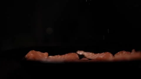 Close-Up of Hands Slicing Fresh Salmon Fillet on a Dark Background 스톡 동영상 303907171