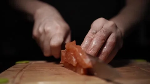 Close-Up of Hands Slicing Fresh Salmon Fillet on a Dark Background Stock-Footage 303907369