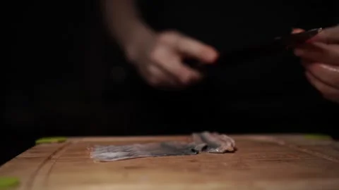 Close-Up of Hands Slicing Fresh Salmon Fillet on a Dark Background Stock Footage 303908030