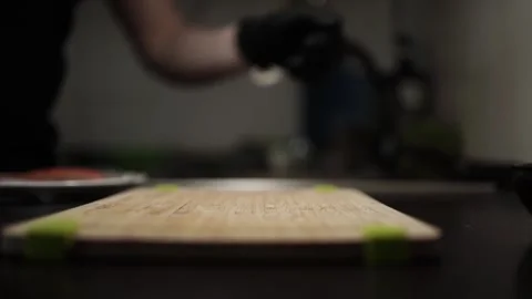 Close-Up of Hands Slicing Fresh Salmon Fillet on a Dark Background Stock Footage 303908124