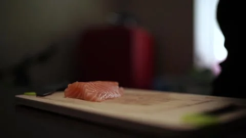 Close-Up of Hands Slicing Fresh Salmon Fillet on a Dark Background Stock-Footage 303908138