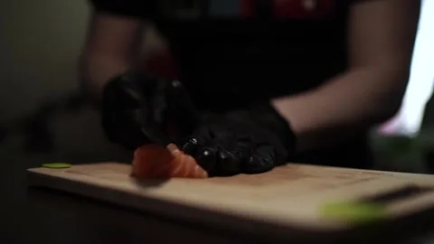 Close-Up of Hands Slicing Fresh Salmon Fillet on a Dark Background Vídeo Stock 303908141