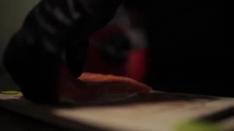 Close-Up of Hands Slicing Fresh Salmon Fillet on a Dark Background 스톡 동영상 303908168
