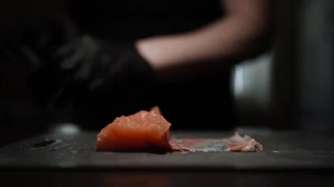 Close-Up of Hands Slicing Fresh Salmon Fillet on a Dark Background 스톡 동영상 303908344