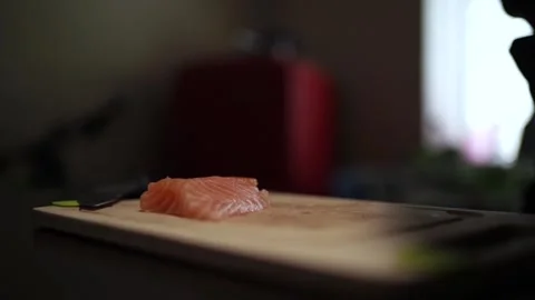 Close-Up of Hands Slicing Fresh Salmon Fillet on a Dark Background 스톡 동영상 303914589