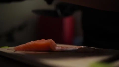 Close-Up of Hands Slicing Fresh Salmon Fillet on a Dark Background 스톡 동영상 303915440