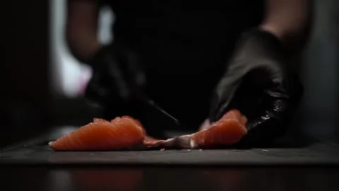 Close-Up of Hands Slicing Fresh Salmon Fillet on a Dark Background Stock-Footage 303915969