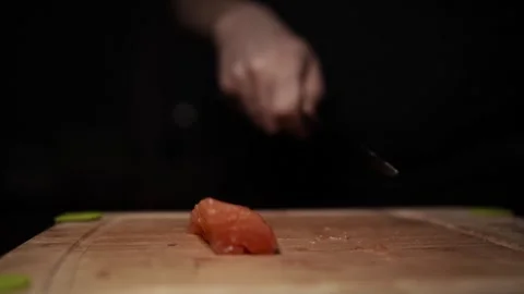 Close-Up of Hands Slicing Fresh Salmon Fillet on a Dark Background Video stock 303920547