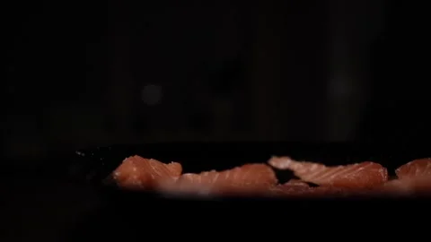 Close-Up of Hands Slicing Fresh Salmon Fillet on a Dark Background 스톡 동영상 303921359