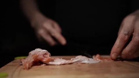 Close-Up of Hands Slicing Fresh Salmon Fillet on a Dark Background Stock Footage 303921491