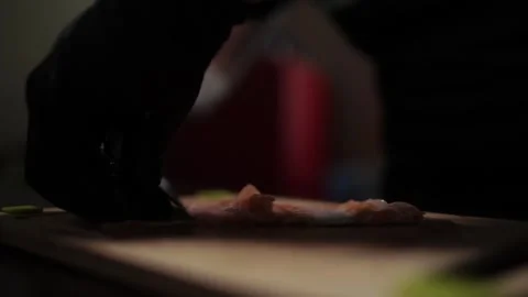 Close-Up of Hands Slicing Fresh Salmon Fillet on a Dark Background 스톡 동영상 303921804