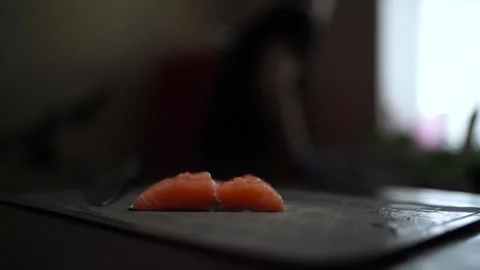 Close-Up of Hands Slicing Fresh Salmon Fillet on a Dark Background Stock Footage 303921859