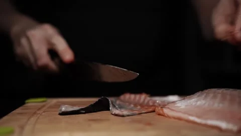 Close-Up of Hands Slicing Fresh Salmon Fillet on a Dark Background Video stock 303923652