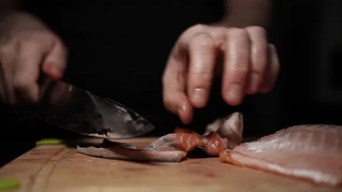 Close-Up of Hands Slicing Fresh Salmon Fillet on a Dark Background 스톡 동영상 303923658