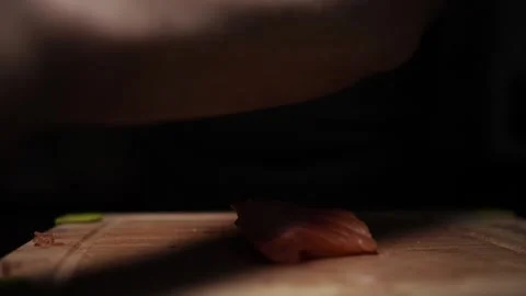 Close-Up of Hands Slicing Fresh Salmon Fillet on a Dark Background Stock Footage 303923698