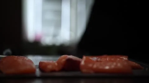 Close-Up of Hands Slicing Fresh Salmon Fillet on a Dark Background Stock Footage 303924092