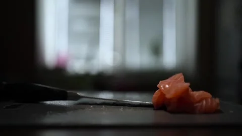 Close-Up of Hands Slicing Fresh Salmon Fillet on a Dark Background 스톡 동영상 303924459