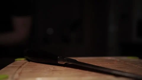 Close-Up of Hands Slicing Fresh Salmon Fillet on a Dark Background Stock Footage 303924864