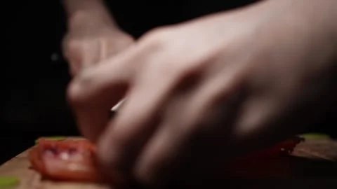 Close-Up of Hands Slicing Fresh Salmon Fillet on a Dark Background 스톡 동영상 303924865