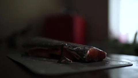 Close-Up of Hands Slicing Fresh Salmon Fillet on a Dark Background 스톡 동영상 303925433