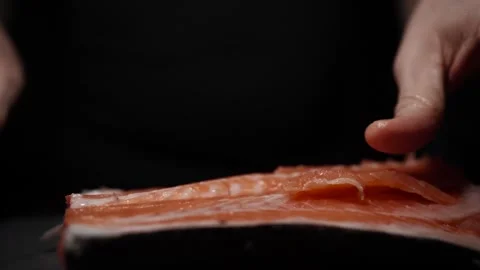 Close-Up of Hands Slicing Fresh Salmon Fillet on a Dark Background 스톡 동영상 303926149