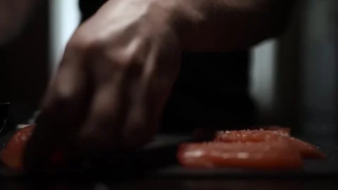 Close-Up of Hands Slicing Fresh Salmon Fillet on a Dark Background Stock Footage 303926162