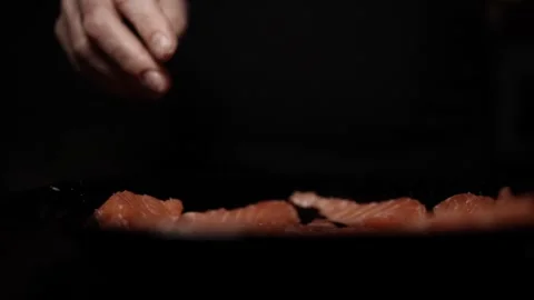Close-Up of Hands Slicing Fresh Salmon Fillet on a Dark Background 스톡 동영상 303926210