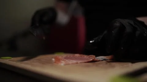 Close-Up of Hands Slicing Fresh Salmon Fillet on a Dark Background 스톡 동영상 303926414