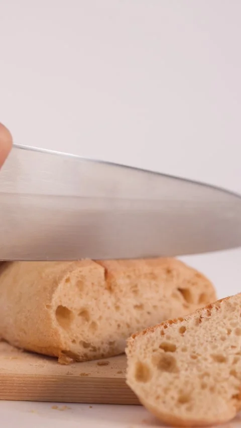 Close Up of Hands Slicing Fresh Sourdough Bread on Wooden Board Stock Footage 337224914