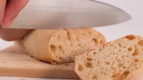 Close Up of Hands Slicing Fresh Sourdough Bread on Wooden Board Stock Footage 337224915