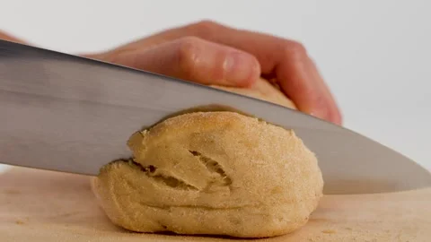 Close Up of Hands Slicing Fresh Sourdough Bread on Wooden Board Stock Footage 337281494