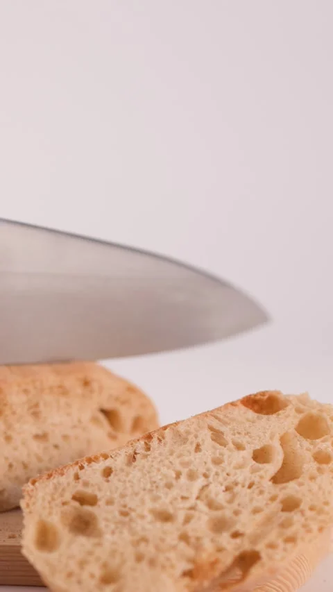 Close Up of Hands Slicing Fresh Sourdough Bread on Wooden Board Stock Footage 337520925