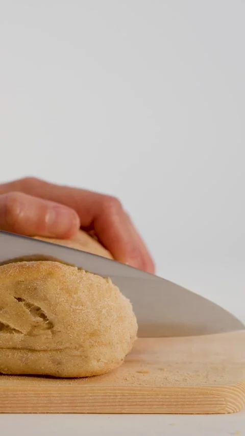 Close Up of Hands Slicing Fresh Sourdough Bread on Wooden Board Stock Footage 337535595