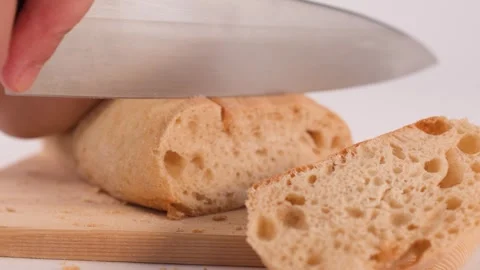 Close Up of Hands Slicing Fresh Sourdough Bread on Wooden Board Stock Footage 337768732