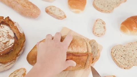 Close Up of Hands Slicing Fresh Sourdough Bread on Wooden Board Stock Footage 339753564