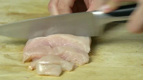 Close Up Hands Slicing Raw Chicken Meat on Cutting Board Video stock 76522293