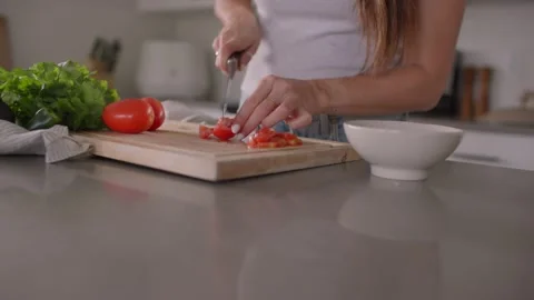 Close up of hands slicing tomatoes on cutting board in kitchen 库存影片 220753824