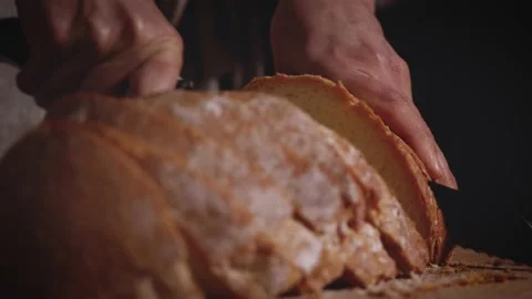 Close up of hands that slicing a traditional bread. Healthy, natural food  Stock Footage 147938692