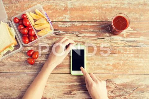 Close up of hands with smartphone food on table Stock Photos