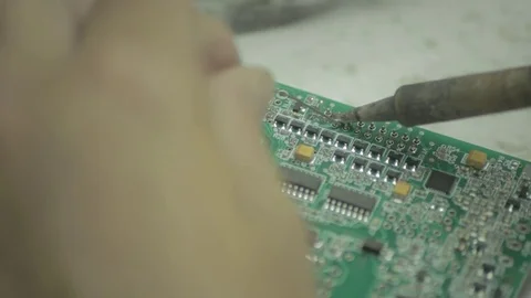 Close-up of hands soldering a component onto a circuit board Stock Footage 78784908