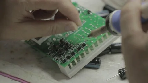 Close-up of hands soldering a component onto a circuit board Stock Footage 78784948