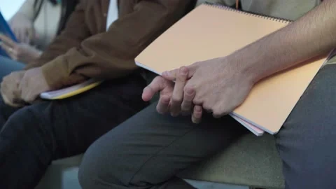 Close up of the hands of some students sitting in a university campus Stock Footage 232090893