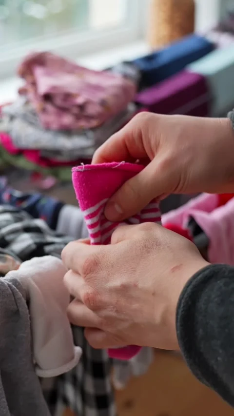 Close-up of hands sorting and folding clothes from a laundry basket at home Stock Footage 327892329