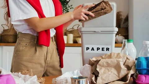 Close up of hands sorting plastic bottles and paper into recycling  bins Stock Footage 336720253