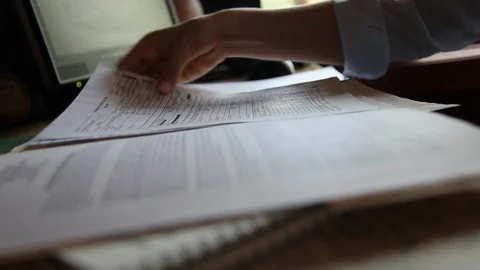 Close-up of hands sorting through papers on a desk Stock Footage 97963712