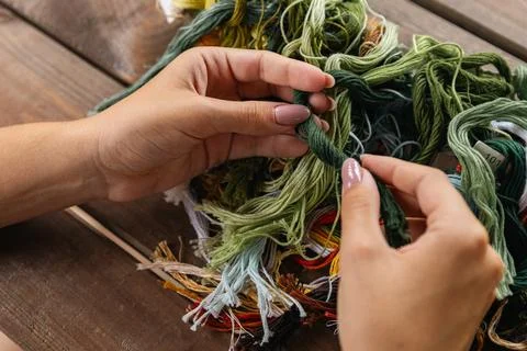 Close-up of hands sorting through a pile of embroidery floss. A large number  Stock Photos